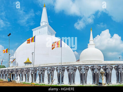 Panorama der Ruwanwelisaya Stupa mit dem Zaun, verziert mit zahlreichen schwarzen Elefanten im Vordergrund, Anuradhapura, Sri Lanka. Stockfoto