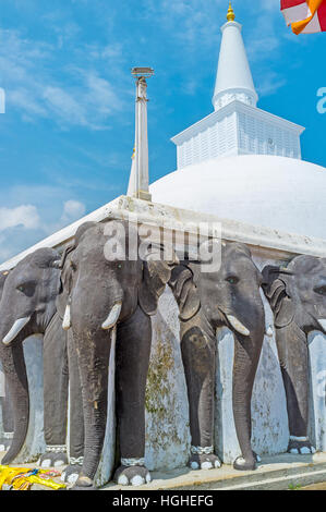 Das Eckelement des Zauns mit Elefanten-Köpfen und der Turm der große Ruwanwelisaya Stupa auf dem Hintergrund, Anuradhapura, Sri Lanka. Stockfoto