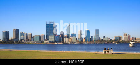 Man saß auf einer Parkbank in Richtung auf die Stadt und den Swan River. Stockfoto