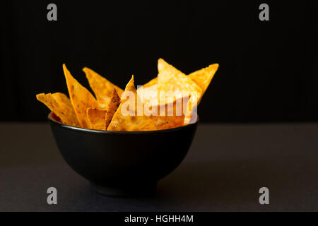 Gebratene würzige mexikanische Tortilla-chips in schwarzer Schale Stockfoto