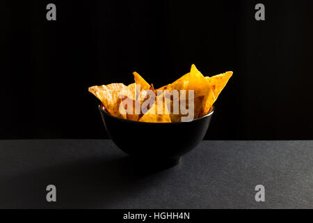 Gebratene würzige mexikanische Tortilla-chips in schwarzer Schale Stockfoto