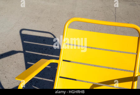 Gelb gefärbt Stuhl und Schatten auf dem Boden. Stockfoto