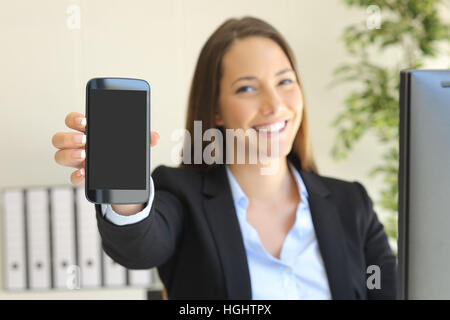 Glücklich Geschäftsfrau zeigt Smartphone-Bildschirm in ihrem Arbeitsplatz Stockfoto