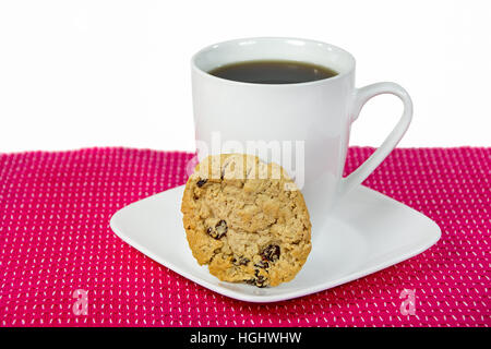 Haferflocken und Rosinen Cookies mit schwarzen Kaffee in weiße Tasse auf quadratischen Platte Stockfoto