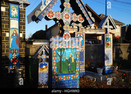 Maramures, einer abgelegenen Karpatenregion von Romania.The Fröhliche Friedhof (Rumänisch: Cimitirul Vesel) ist ein Friedhof im Dorf Sapanta.It ist berühmt für seine bunten Grabsteine mit naiven Gemälden beschreibt in einer ursprünglichen und poetische Art und Weise, die Menschen, die dort, sowie Szenen aus ihrem Leben begraben sind. Der Friedhof Ursprünge mit dem Namen Stan Ioan Patras verbunden sind, ein lokaler Künstler, der die ersten Grabstein Kreuze in 1935.Connections mit der lokalen Dacian Kultur geformt wurden. der Tod ist ein Moment voller Freude und Erwartung für ein besseres Leben. Stockfoto