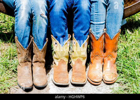 USA, Wyoming, Wolf, Eaton Ranch Nahaufnahme von drei jungen Mädchen Cowboy-Stiefel sitzen auf die Essensglocke Stockfoto