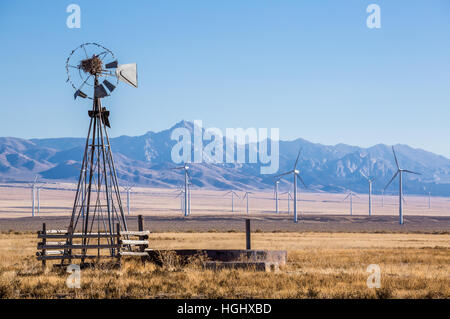 Alt, ruht Windmühle, die fällt auseinander und hat jetzt einen großen Vogel nest auf es vor einem großen Windpark mit 23 sichtbar Windkraftanlagen Stockfoto