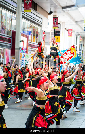 Japan, Kumamoto. Hinokuni Yosakoi Tanzfestival. Weibliches Team Durchführung historischen Tanz in shopping-Arkade. Reihe von Frauen, Arme ausgestreckt. Stockfoto