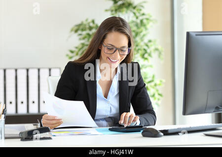 Glücklich Geschäftsfrau trägt Anzug arbeiten mit einem Rechner in einem Schreibtisch im Büro Stockfoto