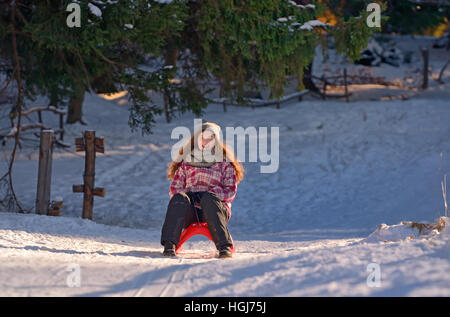 Glückliches Mädchen Hochrutschen im winter Stockfoto