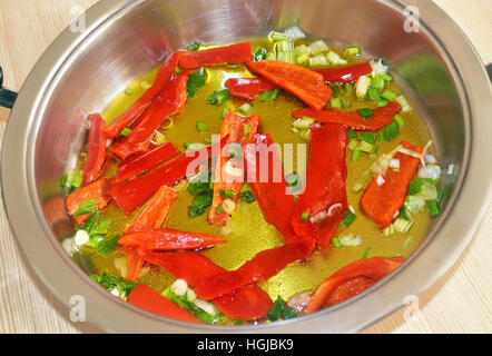 rote Chilischoten und frischen Zwiebeln in griechisches Olivenöl braten Stockfoto