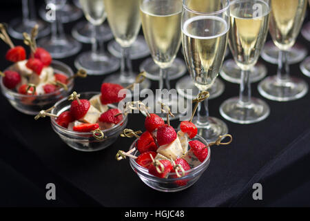 Häppchen Käse und Erdbeeren mit Champagner Stockfoto