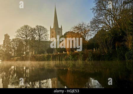 Heilige Dreifaltigkeitskirche Stratford-upon-Avon steht mit Blick auf den Fluss Avon an einem nebligen Wintermorgen. Stockfoto