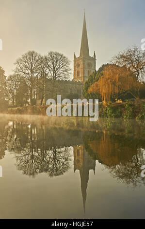 Heilige Dreifaltigkeitskirche Stratford-upon-Avon steht mit Blick auf den Fluss Avon an einem nebligen Wintermorgen Stockfoto