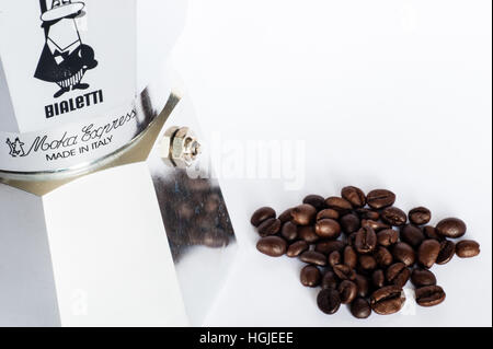 Bialetti Kaffeekanne mit ganzen Kaffeebohnen auf weißem Hintergrund mit Kopierfläche. Stockfoto