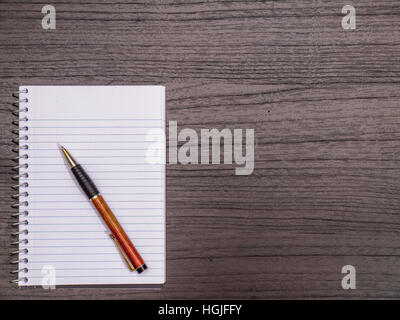 Dunkles Holz Schreibtisch, Spiralblock, Bleistift Stockfoto