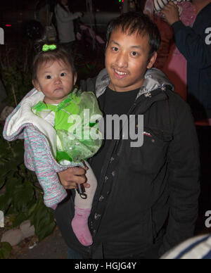 Stolze asiatische Vater hält seinen kostümierten Halloween Trick oder Treater Kleinkind Mädchen für eine Nacht Spaß. St Paul Minnesota MN USA Stockfoto