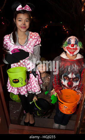 Teen asiatisch-amerikanische Mädchen in einer möglichen Pokémon Polka Dot Kleid und böser Clown Halloween-Kostüme. St Paul Minnesota MN USA Stockfoto