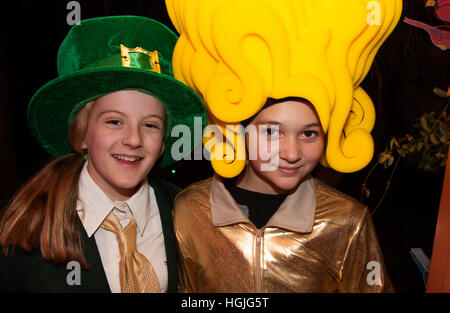 Mädchen in St Patricks Day Kostüm und ein weiteres in Big Fun - Surfer Girl Schaum Perücke Halloween-Kostüm.  St Paul Minnesota MN USA Stockfoto