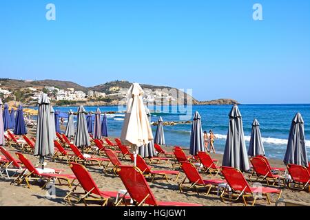 Sonnenliegen und Touristen am Livadi Strand mit Blick entlang der Küste, Bali, Kreta, Griechenland, Europa. Stockfoto