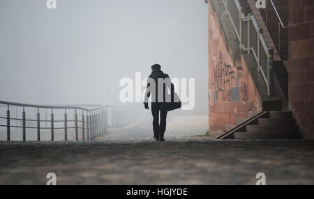 Frankfurt am Main, Deutschland. 23. Januar 2017. Ein Mann geht in der Nähe der Ufer des Mains in Frankfurt am Main, 23. Januar 2017. Eine dicke Schicht von Nebel sowie bittere Frost deckt die Stadt mit bis zu minus 17 Grad. Foto: Susann Prautsch/Dpa/Alamy Live News Stockfoto