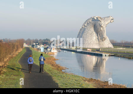 Falkirk, Schottland. 23. Januar 2017. UK-Wetter - zwei Frauen genießen die Sonne an einem kalten klaren Morgen zu Fuß durch die Kelpies in Forth und Clyde Canal wider. In einer Höhe von 30 Metern sind die zwei Pferdeköpfe - erstellt von Andy Scott - die weltweit größte equine Skulpturen Credit: Kay Roxby/Alamy Live News Stockfoto