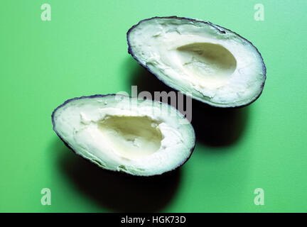 Reife Avocado halbieren am grünen Tisch Stockfoto