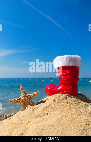 Lustige Seesterne und roten Boot vom Weihnachtsmann am Strand für Weihnachten Stockfoto