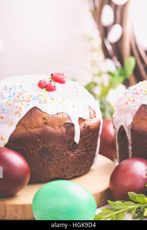 Traditionelle Osterkuchen mit Zuckerguss, mit bemalten Eiern dekoriert. Urlaub Tisch, Pastell getönt Stockfoto