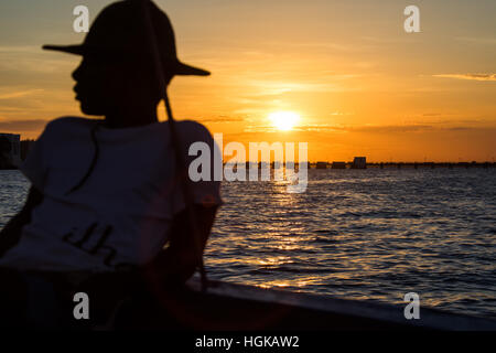 Junger Mann auf einer Dhau vor der Festung, Mozambique Island (Ilha de Mocambique), Mosambik Stockfoto