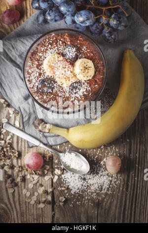 Schokolade Chia Pudding mit Früchten auf der hölzernen Tischplatte-Ansicht Stockfoto