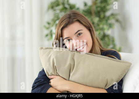 Glücklich Teen Mädchen posiert, betrachtet man Sie sitzen auf einer Couch im Wohnzimmer zu Hause Stockfoto