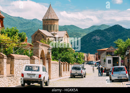 Mzcheta, Georgia - 20. Mai 2016: Gepflasterte Straße mit parkenden Autos und Swetizchoweli-Kathedrale der lebenden Säule, georgische orthodoxe Kirche auf grün M Stockfoto