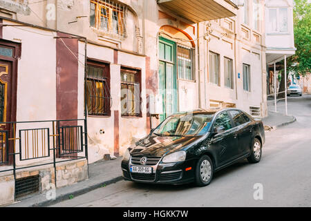 Tiflis, Georgien - 20. Mai 2016: Die Ansicht der geparkten schwarzen glitzerte Volkswagen Jetta Auto auf dem Bürgersteig der Straße mit alten Gebäuden im Sommer Tag. Stockfoto