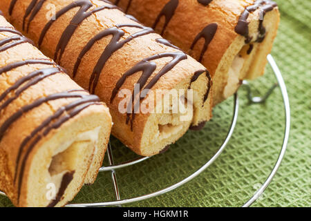 Süße Rouladen (Roulade) mit weißen Creme auf grüne Tischdecke Stockfoto