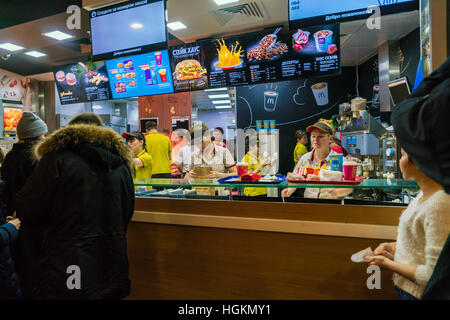 Sankt PETERSBURG, Russland - 25. Dezember 2016: Die Mitarbeiter des Netzes von Fastfood McDonald betreuen Besucher Stockfoto