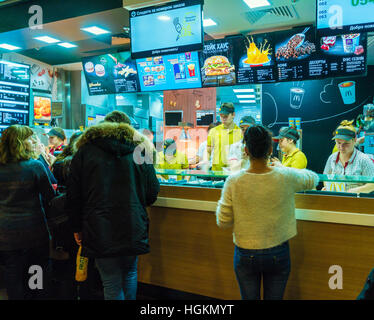 Sankt PETERSBURG, Russland - 25. Dezember 2016: Die Mitarbeiter des Netzes von Fastfood McDonald betreuen Besucher Stockfoto