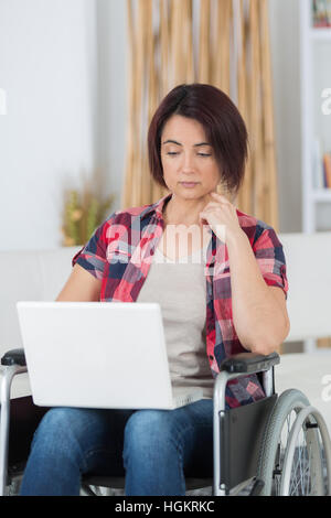 behinderte Frau, die im Web Surfen Stockfoto