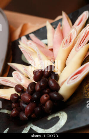 Fleisch und Käse Rollen mit Oliven mit Kunstlicht geschossen Stockfoto