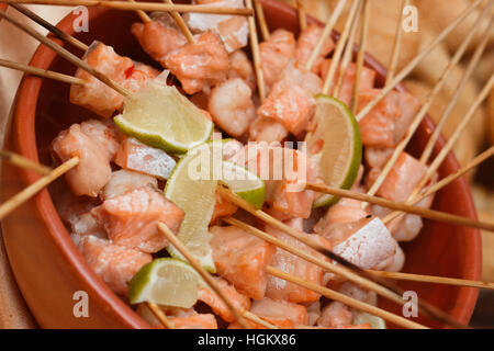 Lachs und Kalk-Spieße in einer Keramikschale Stockfoto