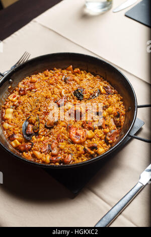 Paella in einer Metall-Pfanne mit Kunstlicht geschossen Stockfoto