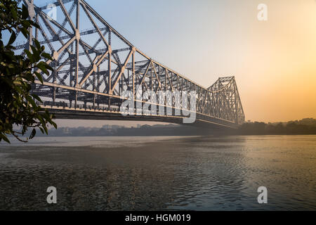 Historische Howrah Bridge über den Fluss Hooghly bei Sonnenaufgang. Stockfoto