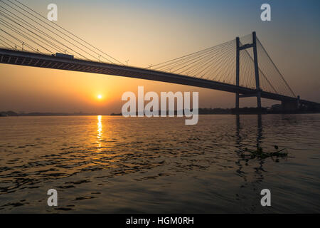 Vidyasagar Brücke (setu) auf dem Fluss Hooghly in Silhouette bei Sonnenuntergang. Stockfoto