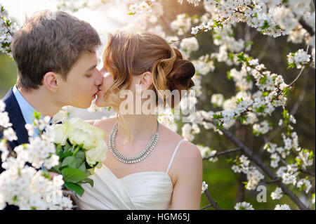 Braut und Bräutigam bei der Hochzeit-Kuss im Frühjahr laufen Park Stockfoto