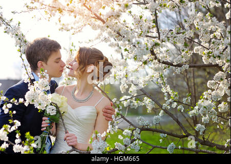 Braut und Bräutigam bei der Hochzeit-Kuss im Frühjahr laufen Park Stockfoto