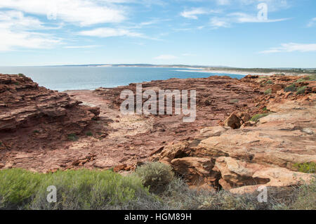 Schroffe Pfad durch das rote Sandstein-Gelände in Red Bluff Beach mit dem indischen Ozean Seelandschaft in Kalbarri, Western Australia. Stockfoto