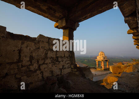 Morgen Sonnenstrahlen fallen auf den Ruinen von Hampi. Eine Ansicht der Felsentempel mit blauem Himmel als Hintergrund von Matanga Hill, Hampi, Indien Stockfoto