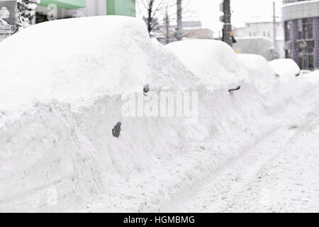 Voll Schnee bedeckte Fahrzeuge während eines schweren Schneefalls in der Stadt gesehen werden Stockfoto