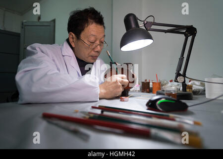 (170111)--JINGZHOU, 11. Januar 2017 (Xinhua)--Du Daozi Reparaturen eine Tasse eared Lack Chinas streitenden Reiche (475 v. Chr. - 221 v. Chr.) im Kulturdenkmal Erhaltung Center in Jingzhou Stadt, Zentral-China Hubei Provinz, 10. Januar 2017. Du Daozi ist ein Spezialist für Bambus und Holz Lacquerware Restaurierung. Er wurde in Jingzhou Museum eingeführt und Lack Restaurierungsarbeiten im Jahr 1987 begann. In den vergangenen 30 Jahren hat Du mehr als 2.000 Stück der Lacquerwares, einschließlich viele kulturelle Relikte von großem historischen Wert wiederhergestellt. (Xinhua/Xiong Qi) (Swt) Stockfoto