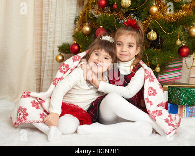 zwei Mädchen Porträt in Weihnachts-Dekoration, Winter Urlaub Konzept, geschmückten Tannenbaum und Geschenke Stockfoto